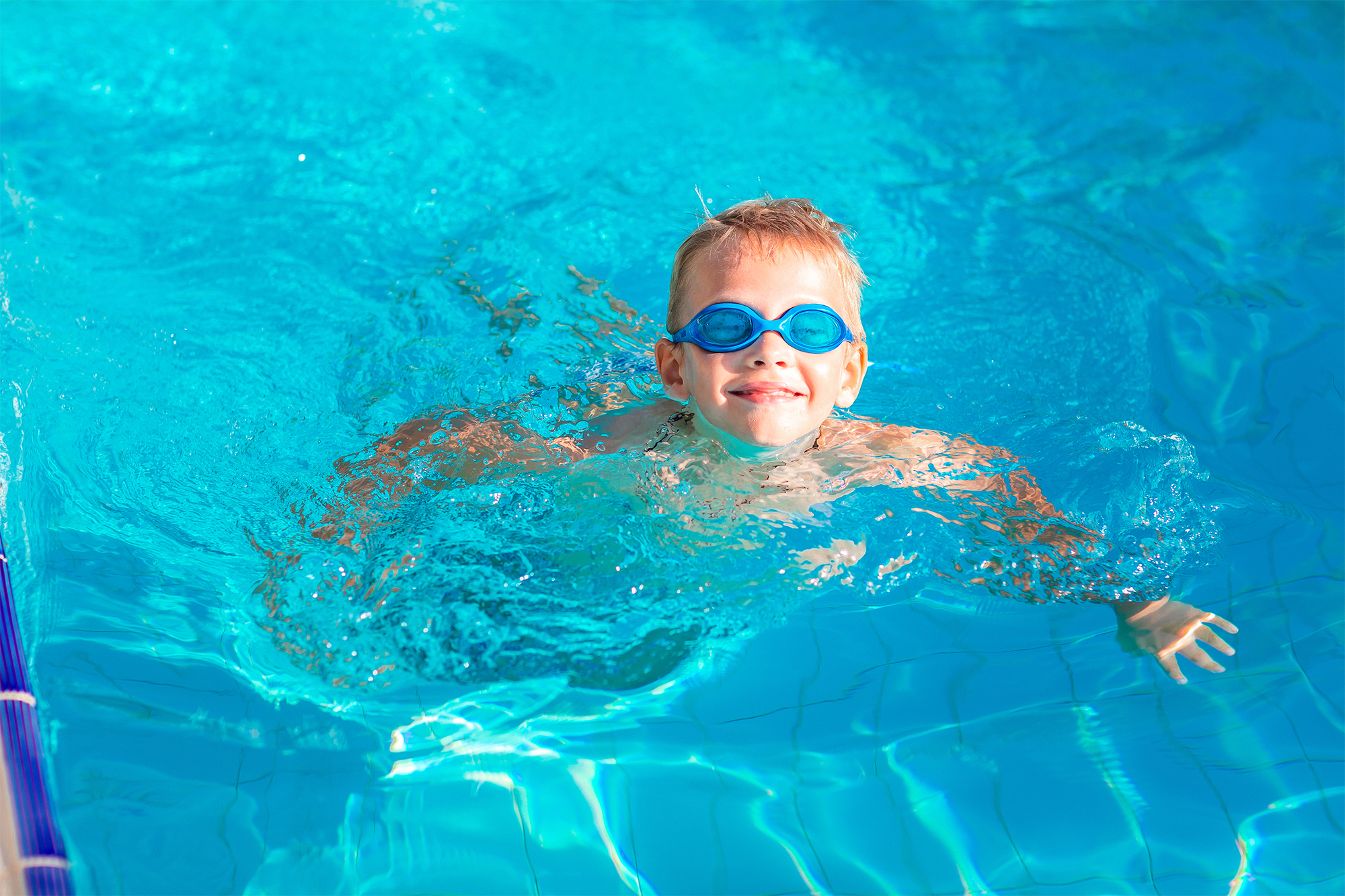Cute Happy Little Boy with Autism In Goggles Swimming