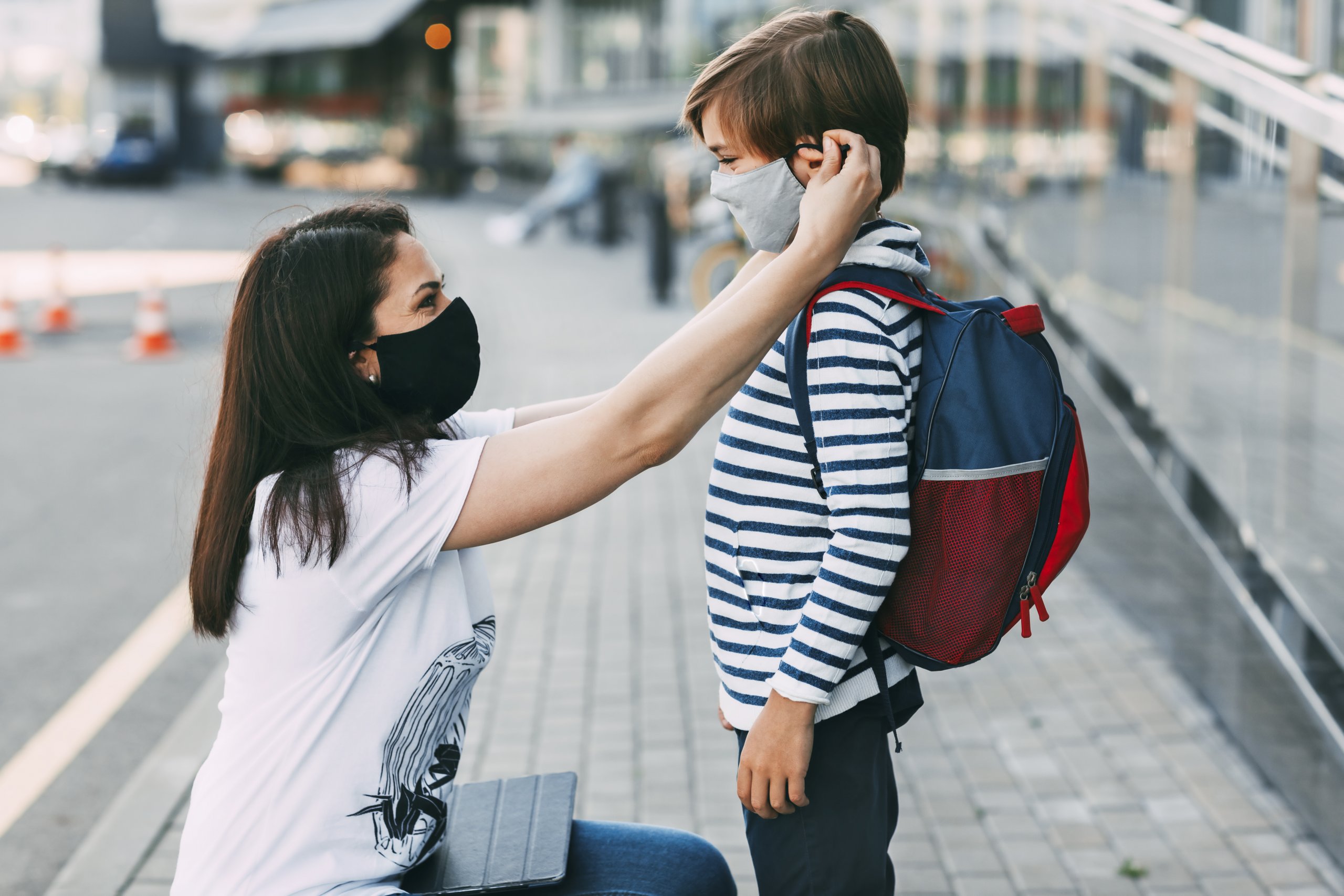 Mother Adjusts Her Sons Mask. A Mother And Child On Their Way To