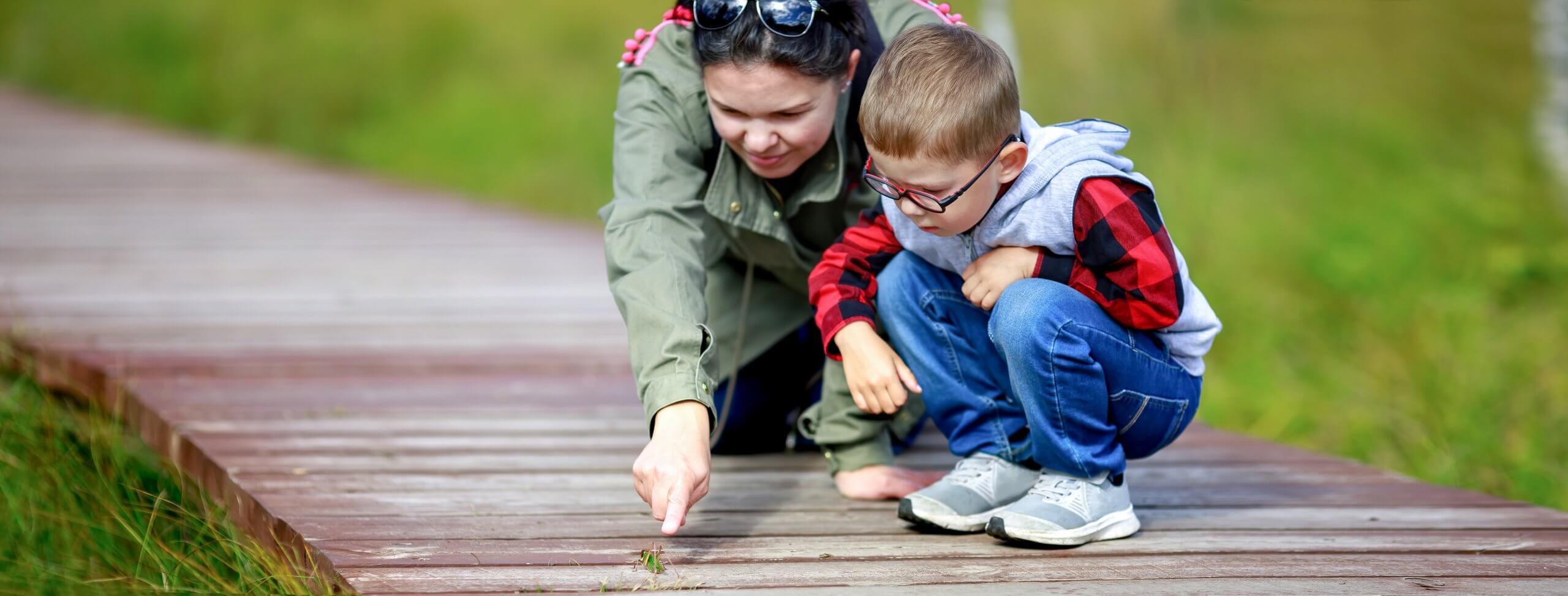 Mother Spends Time With Her Little Son At Nature Park. Mom Point